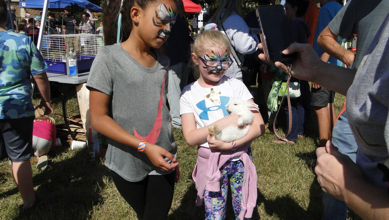 Cute girls holding a rabbit from the petting zoo.